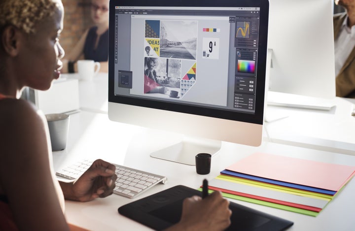 Graphic designer looks at computer screen