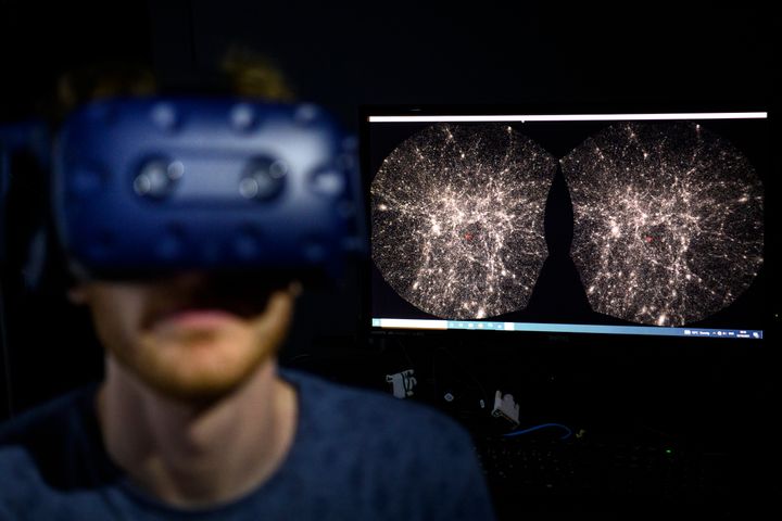 In this Oct. 12, 2021, file photo, Hadrien Gurnel, software engineer at EPFL's Laboratory for Experimental Museology, explores with a virtual reality helmet the most detailed 3D map of the universe with the virtual reality software VIRUP.