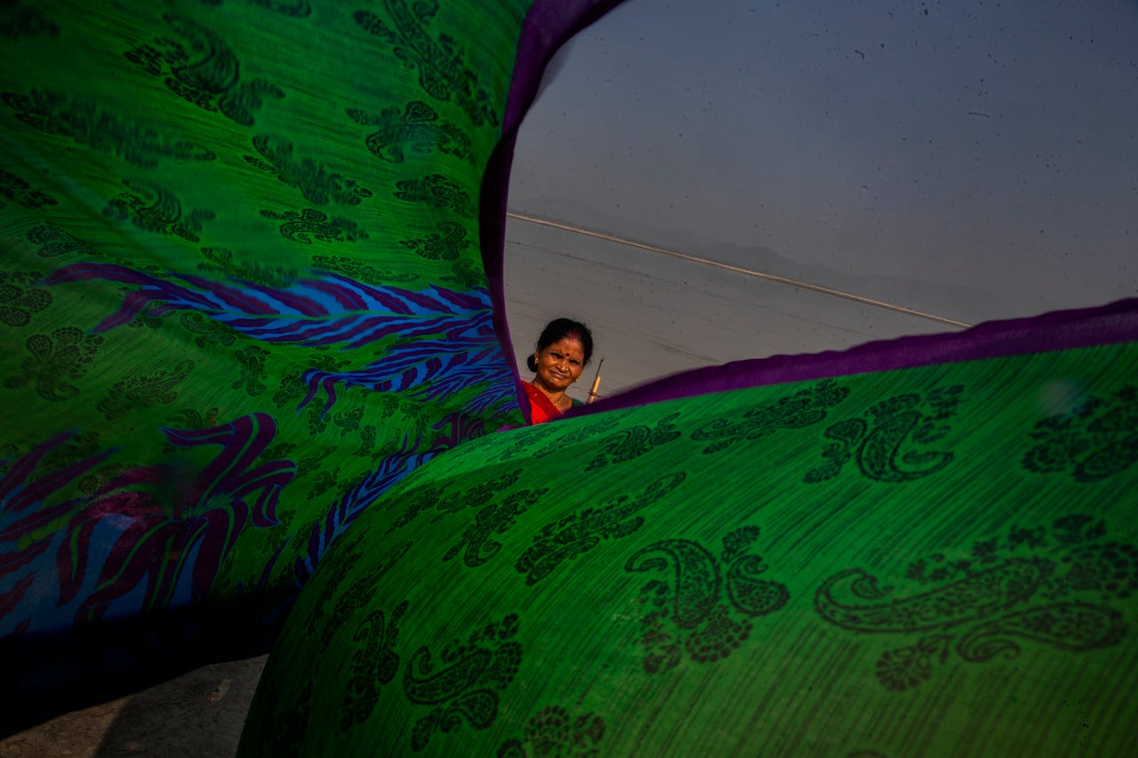 A washer dries clothes on the banks of the Brahmaputra in Guwahati, India, on Friday. Brahmaputra is one of Asia's largest rivers, passing through Tibet, India and Bangladesh before converging into the Bay of Bengal.