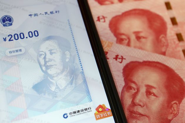 China's official app for digital yuan is seen on a mobile phone next to 100-yuan banknotes in this illustration...