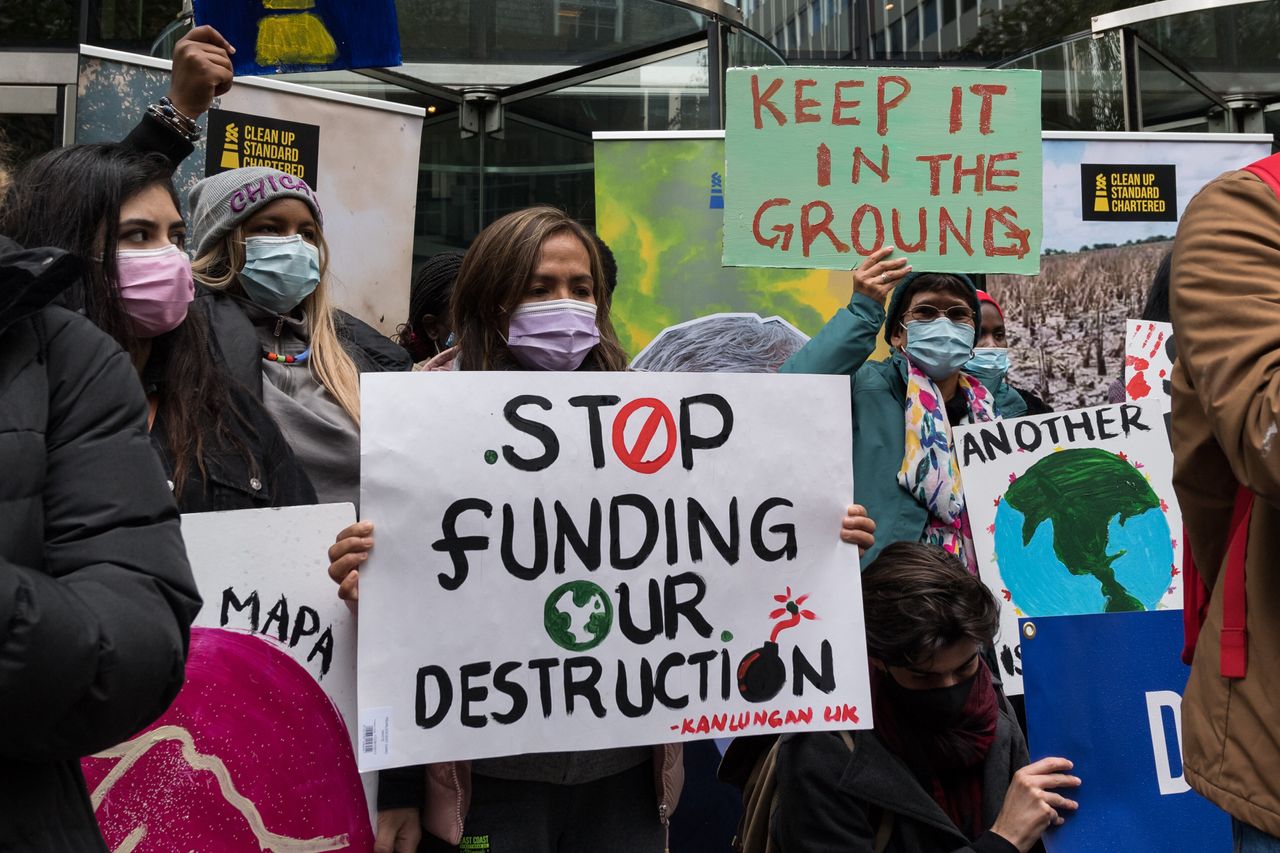 Youth climate activists protest financing fossil fuel projects outside Standard Chartered headquarters during Defund Climate Chaos global day of action in London on Oct. 29, 2021.