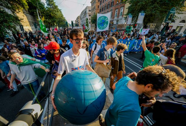 Ένας διαδηλωτής παρελαύνει με μια αυτοσχέδια σφαίρα του πλανήτη γη στη Ρώμη, το Σάββατο 30 Οκτωβρίου 2021, την ημέρα που ξεκίνησε μια σύνοδος κορυφής της Ομάδας των 20 στην ιταλική πρωτεύουσα.( AP Photo/Luca Bruno)