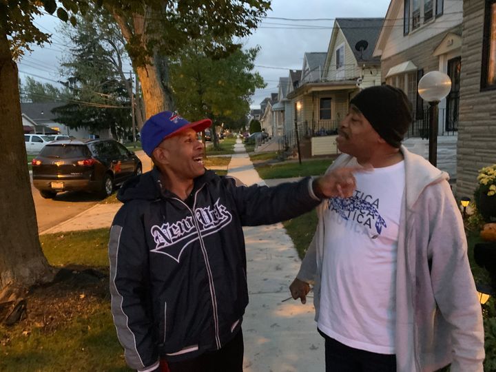 Andy Pleasant (left) has a friendly argument about the mayoral race with neighbor Paul Rhines. Both men are unhappy with Brown, but only one is voting for Walton.
