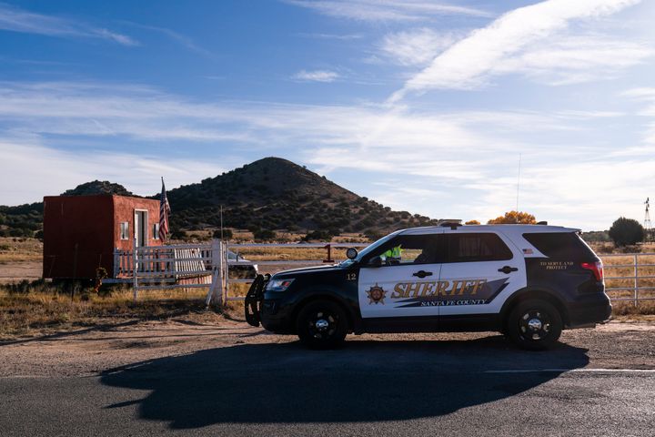 A Santa Fe County Sheriff's deputy briefly talks with a security guard at the entrance to the Bonanza Creek Ranch — where "Rust" had been filmed — in Santa Fe, New Mexico, on Oct. 15.