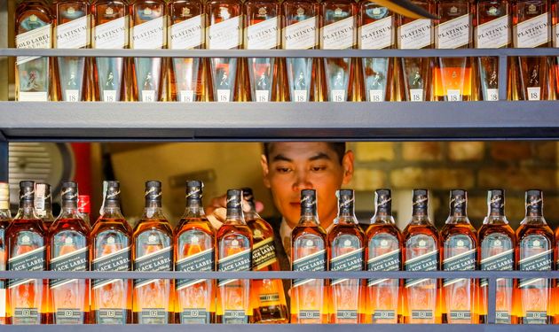 A bartender takes a bottle of Johnnie Walker whisky in Almaty, Kazakhstan June 22, 2017. REUTERS/Shamil...