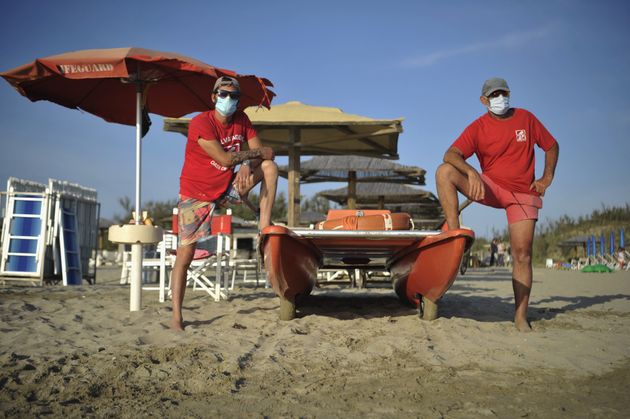 PISA, ITALY - MAY 24: Lifeguards on the beach wearing a protective mask stands in the 'Oasi del Mare'...