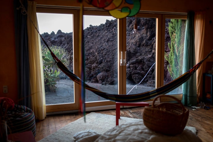 Lava from a volcano advances towards a house.