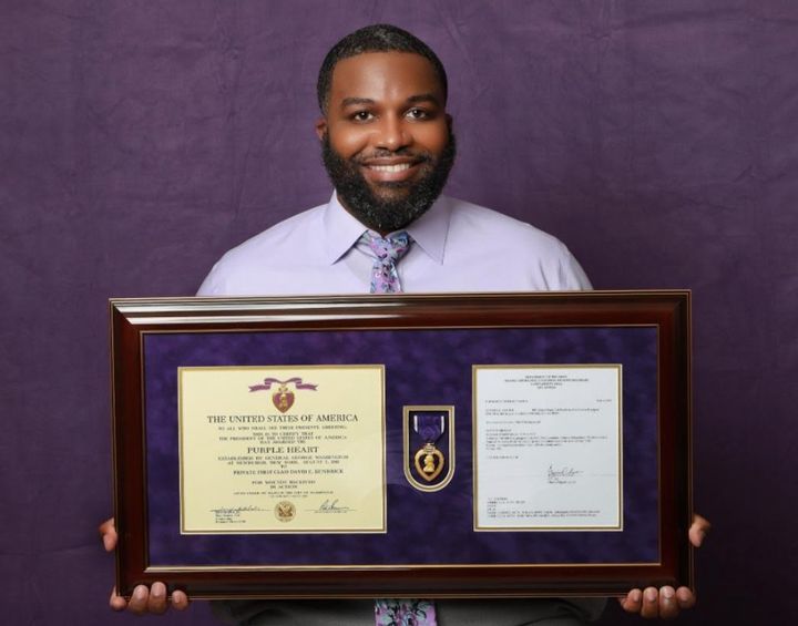 The author holding his Purple Heart medal in 2021.