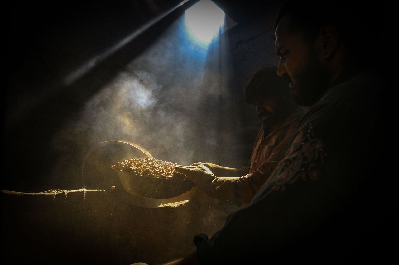 Shopkeepers roast peanuts inside their shop in Lahore, Pakistan, on Oct. 31.