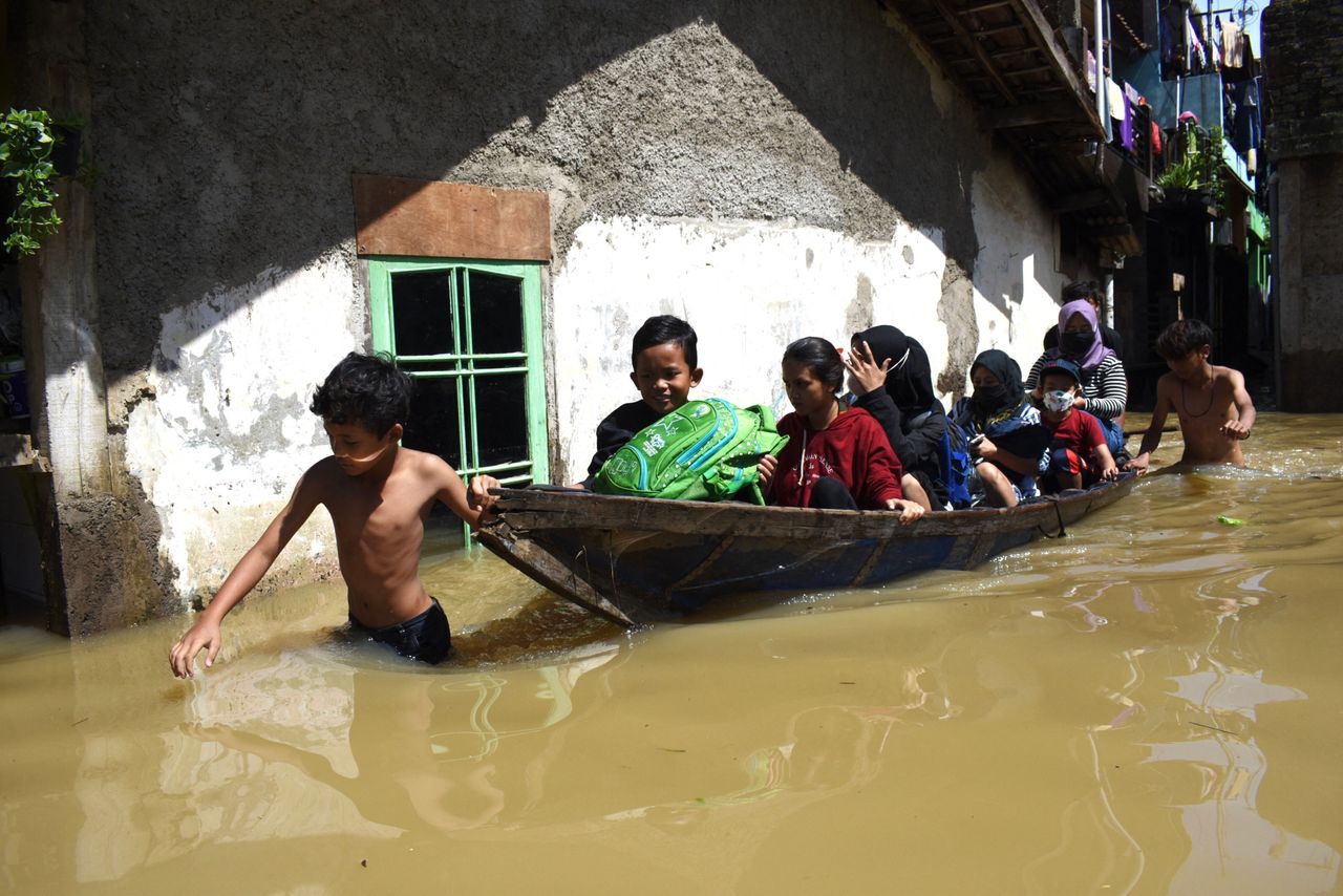 A family evacuates from their flooded home following heavy rain in Bandung, Indonesia, on Nov. 3.