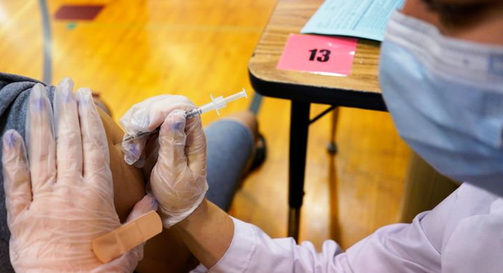 A health care worker prepares inject a student with a dose of the Pfizer COVID-19 vaccine during a vaccination clinic at London Middle School in Wheeling, Ill., Friday, June 11, 2021. 