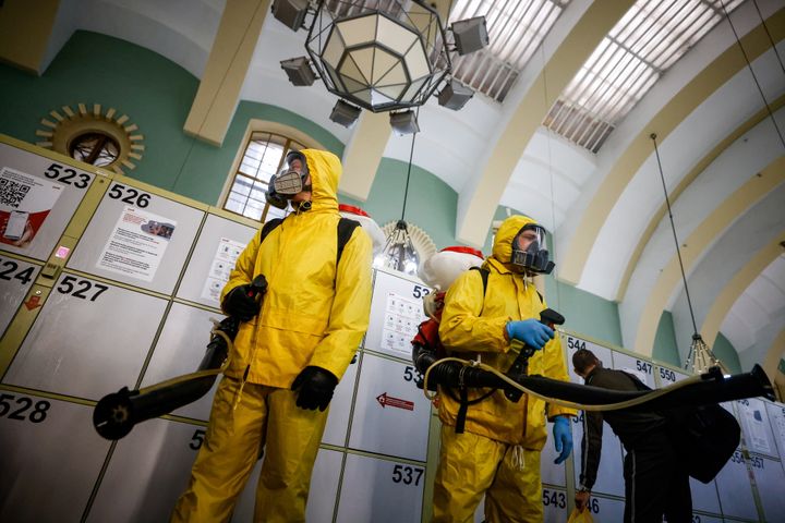 Ειδικοί που φορούν εξοπλισμό ατομικής προστασίας (PPE) ψεκάζουν απολυμαντικό κατά την απολύμανση του σιδηροδρομικού σταθμού Kazansky εν μέσω της επιδημίας.