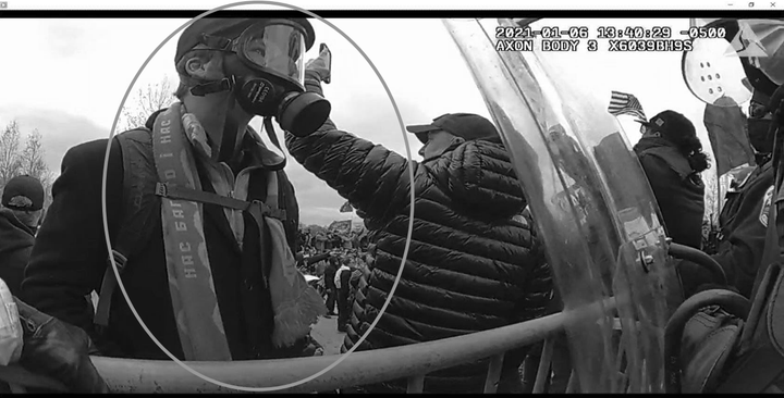 Neumann wearing a gas mask and a scarf referencing the Ukrainian Orange Revolution at the U.S. Capitol on Jan. 6.