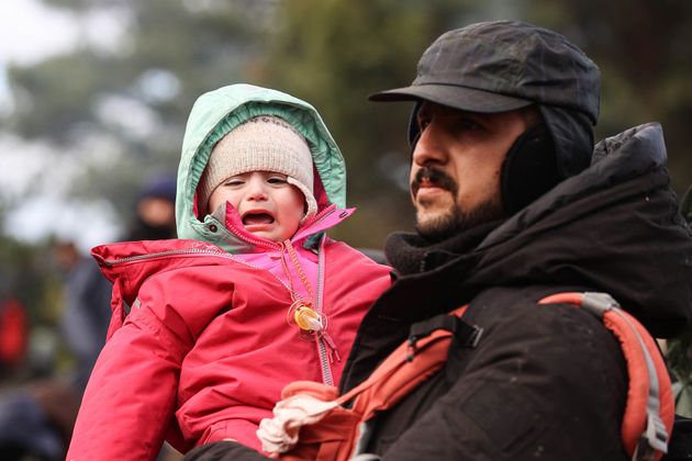 ベラルーシとポーランドの国境で、子供を抱きしめる男性