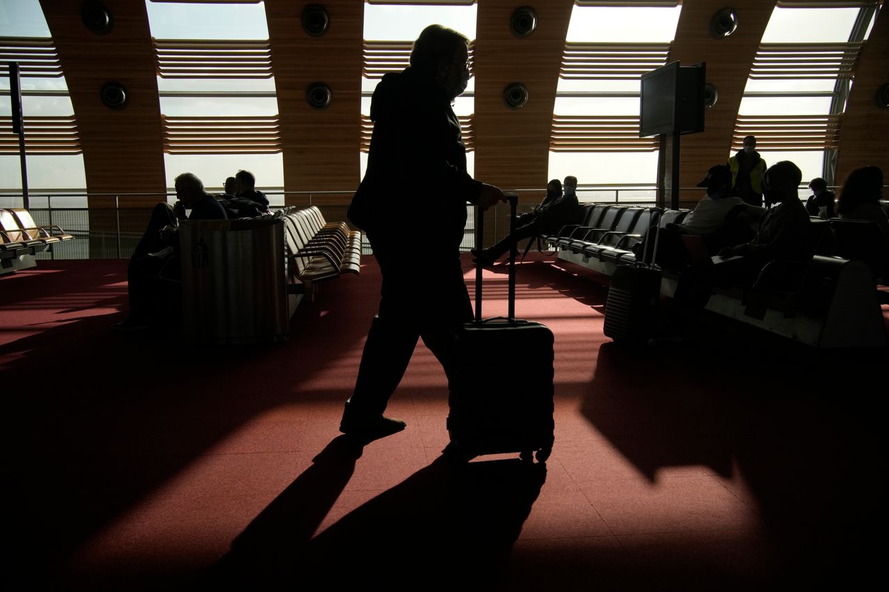Ένας επιβάτης για τις Ηνωμένες Πολιτείες μεταφέρει τις αποσκευές του στη ζώνη αναμονής πριν επιβιβαστεί σε πτήση στο αεροδρόμιο Charles de Gaulle, βόρεια του Παρισιού, Δευτέρα, 8 Νοεμβρίου 2021.