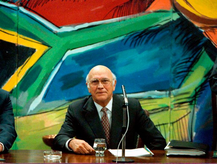 Former president and leader of the National Party F. W. de Klerk, discusses his resignation, below a mural of the new South African flag, at a National Party Caucus meeting in Cape Town, on Aug. 26 1997. 