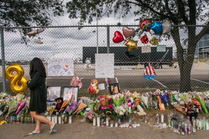 A woman walks past a memorial to those who died at the Astroworld festival.