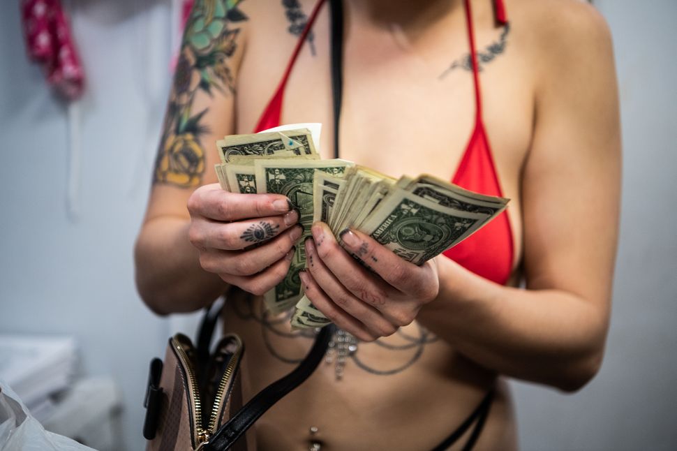Nikki, a stripper, counts money she made while performing on a busy night at Penthouse in Tampa, Florida, after local NFL team the Buccaneers won their game on Sept. 10, 2021.