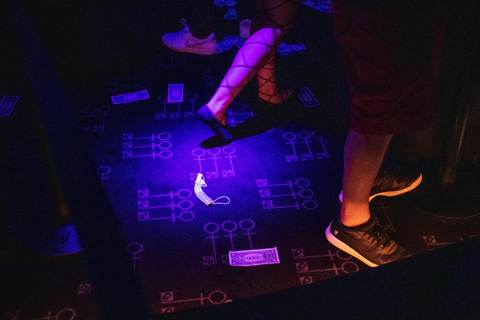 A dancer walks past a surgical mask discarded on the floor of Penthouse. 