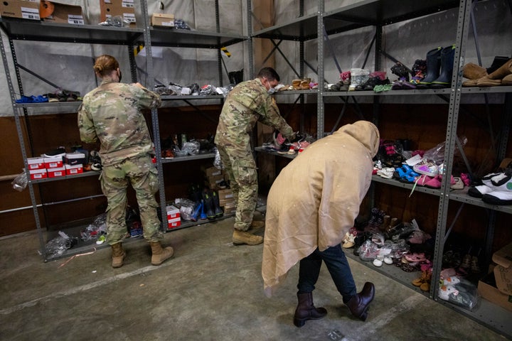 An Afghan refugee looks for shoes at the donation center. 