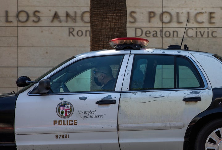 A member of the LAPD sits inside his squad car, parked outside their headquarters on 1st St. in downtown Los Angeles.
