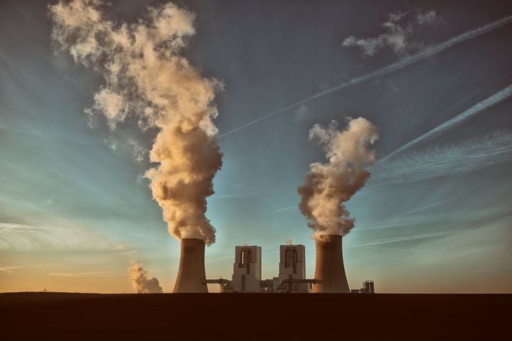 Toned high resolution photograph of a modern brown-coal burning power plant with pollution.