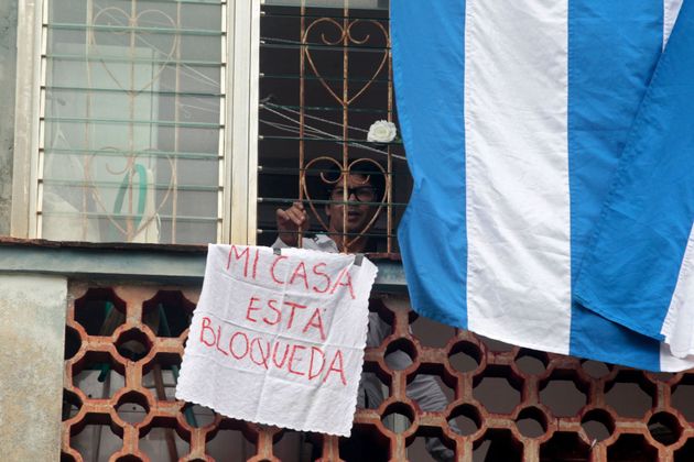Yunior García, en la ventana de su casa, denunciando su