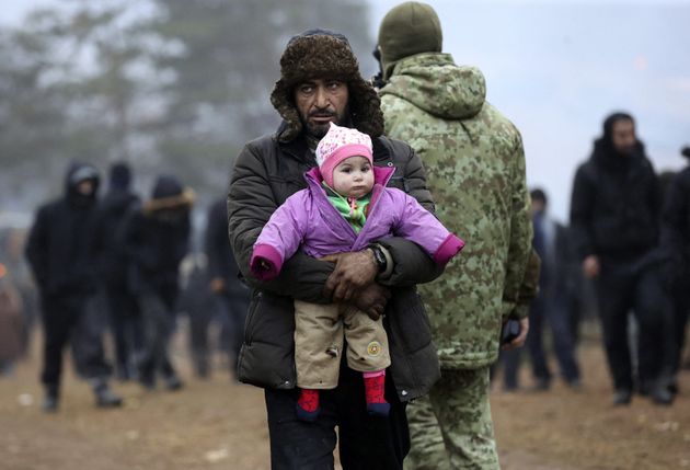 Un hombre abraza a una niña en un campamento improvisado en la frontera entre Bielorrusia y Polonia,...