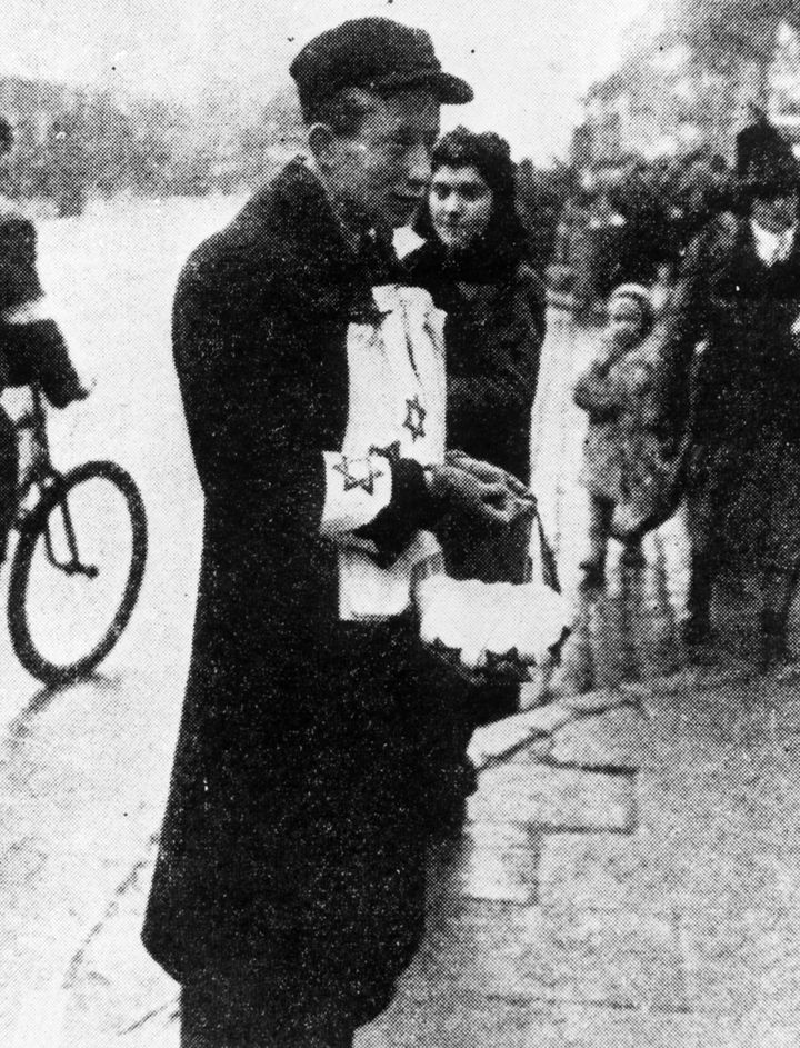 1940年ごろ、ポーランドのワルシャワで「ダビデの星の腕章」を売るユダヤ人の露天商