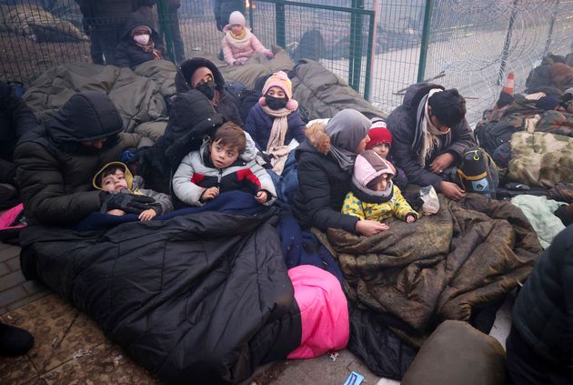 Un grupo de migrantes se protege del frío con mantas en la frontera entre Bielorrusia y