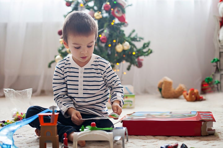 Un niño juega con uno de sus regalos de Navidad