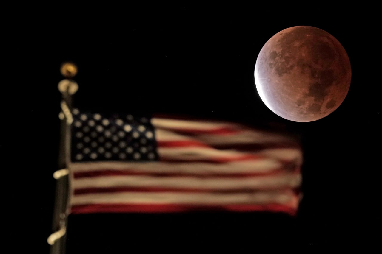 The earth's shadow covers the full moon during a partial lunar eclipse in downtown Kansas City, Missouri, on Nov. 19.