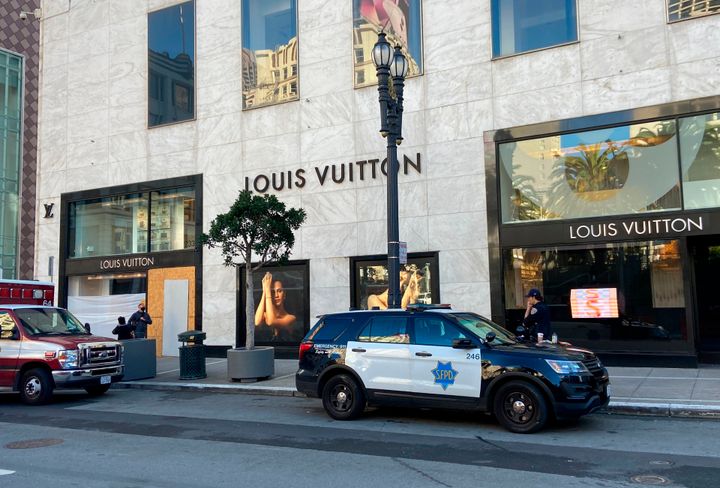 Police officers and emergency crews park outside the Louis Vuitton store in San Francisco's Union Square on Nov. 21, 2021, after looters ransacked businesses late Saturday night.