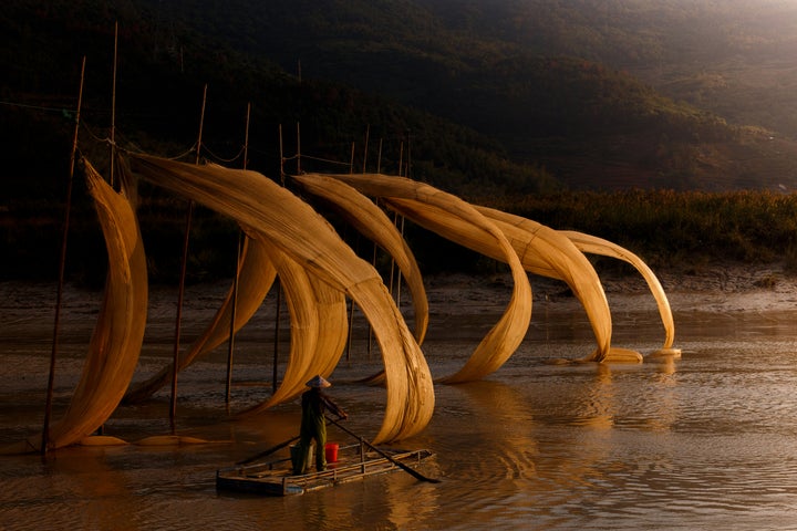 A fisherman rows into the sunset in Xiapu, China in hope of catching some fish in the quiet of the night, by Lorenzo Perotti.