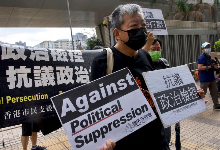 Pro-democracy activist Lee Cheuk-yan holds placards as he arrives at a court in Hong Kong in April. A report released Monday found that democracy is deteriorating around the world.