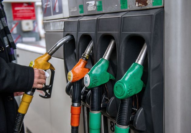 Des voitures passent devant un panneau indiquant les prix dans une station-service sur l'autoroute A25...