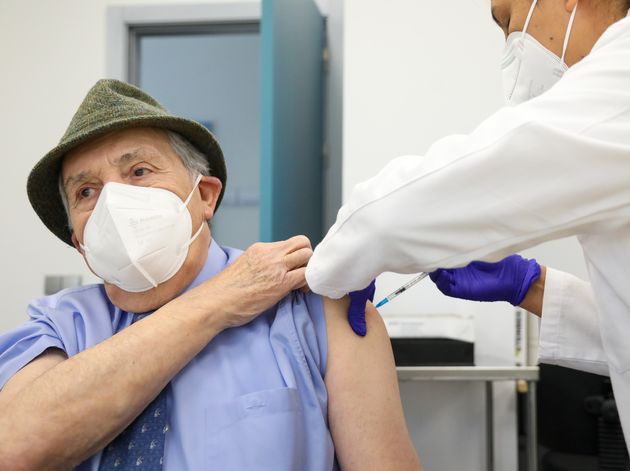 Un sanitario pone la vacuna a una persona de avanzada