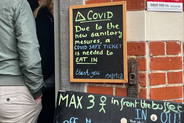A notice board of COVID-19 preventive measures is seen outside a restaurant in Brussels, Belgium, Nov....