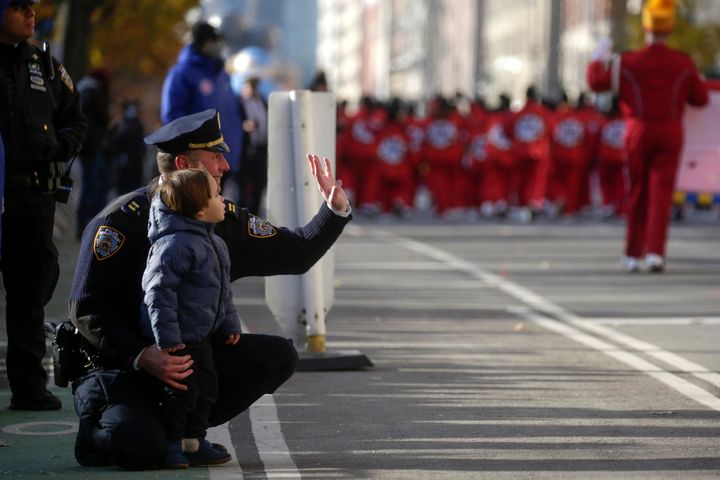 An NYPD officer and his son attend the 95th-annual Macy's Thanksgiving Day Parade in new York.