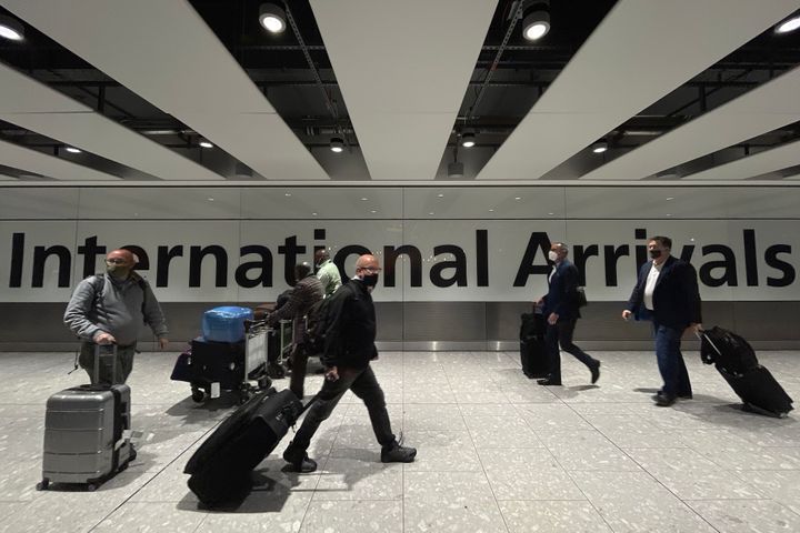 International passengers walk through the arrivals area at Terminal 5 at Heathrow Airport on November 26, 2021 in London, England. (Photo by Leon Neal/Getty Images)