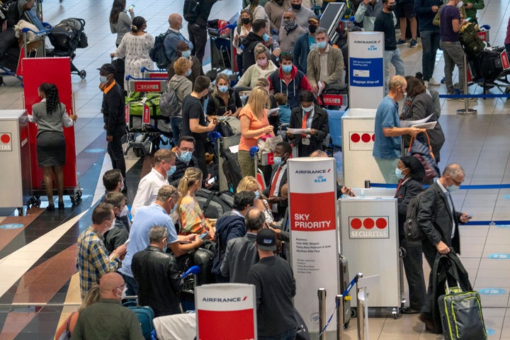 La gente hace fila para tomar el vuelo de Air France a París en el Aeropuerto Internacional OR Tambo en Johannesburgo, Sudáfrica, el viernes 26 de noviembre de 2021. Varias naciones se movilizaron para detener los viajes aéreos desde el sur de África el viernes en reacción a la noticia de un nueva variante de COVID-19 potencialmente más transmisible que se ha detectado en Sudáfrica.  (Foto AP / Jerome Delay)