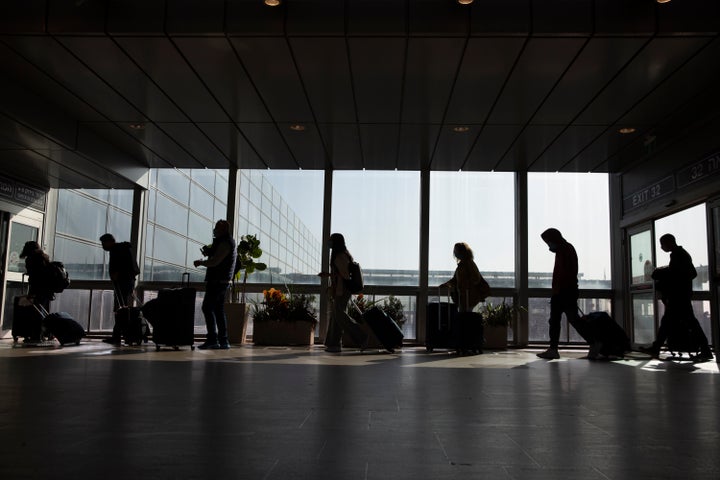 Des voyageurs marchent avec leurs bagages à l'aéroport Ben Gourion près de Tel Aviv, en Israël, le dimanche 28 novembre 2021. Israël a approuvé dimanche l'interdiction d'entrée aux ressortissants étrangers et l'utilisation d'une technologie controversée pour la recherche des contacts dans le cadre de ses efforts pour réprimer sur une nouvelle variante du coronavirus.  (Photo AP/Ariel Schalit)