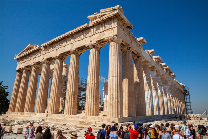 Athens, Greece - July 02, 2018: Parthenon at Acropolis with tourists visiting. The Parthenon is in the process of reconstruction and conservation.