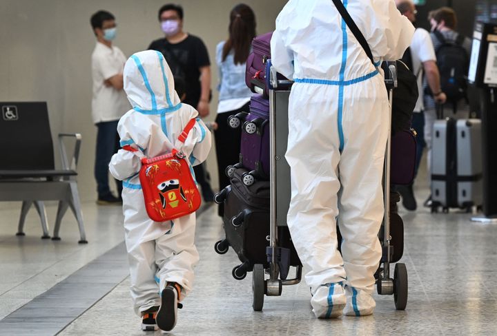 International travellers wearing personal protective equipment (PPE) arrive at Melbourne's Tullamarine Airport on Nov. 29, 2021, as Australia records its first cases of the omicron variant of COVID-19.