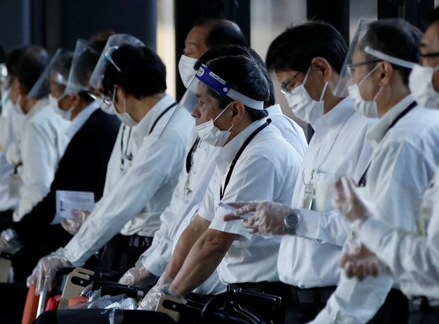 Tόκιο 30 Νοεμβρίου 2021. Προσωπικό του αεροδρομίου με μάσκες στα πρόσωπα εν αναμονή επιβατών που χρησιμοποιούν καροτσάκια για να μετακινηθούν. Πτήσεις, όμως, γίνονται μόνο από το εσωτερικό, αφού έχουν απαγορευτεί τα ταξίδια από το εξωτερικό προς την Ιαπωνία, υπό το φόβο της παραλλαγής Όμικρον. REUTERS/Kim Kyung-Hoon