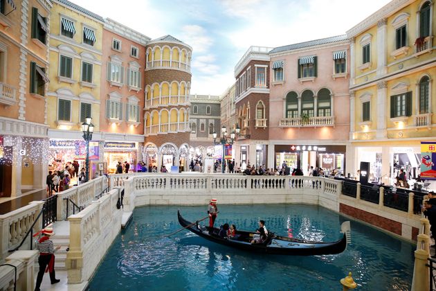 People take a gondola ride inside the shopping mall of the Venetian Macao hotel and casino in Macau,...