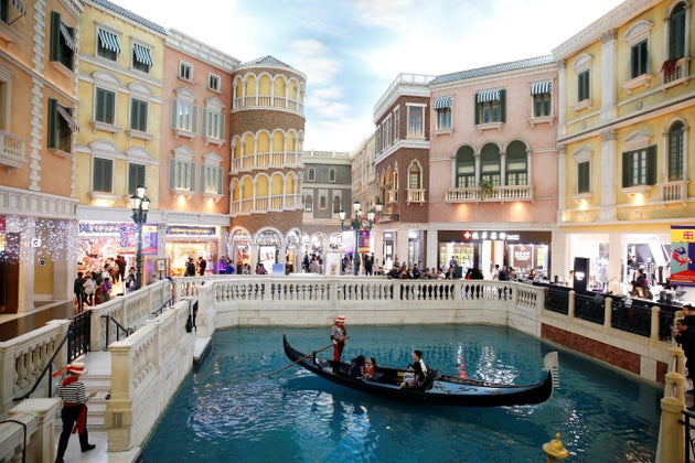 Oamenii fac o plimbare cu gondola în centrul comercial al hotelului și cazinoului Venetian Macao din Macao,...