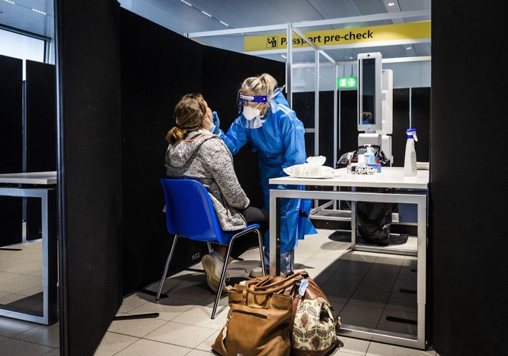 Travelers from South Africa are tested for COVID-19 on arrival in a specially designed test street at Schiphol airport in the Netherlands on November 30, 2021. (Photo by REMKO DE WAAL/ANP/AFP via Getty Images)