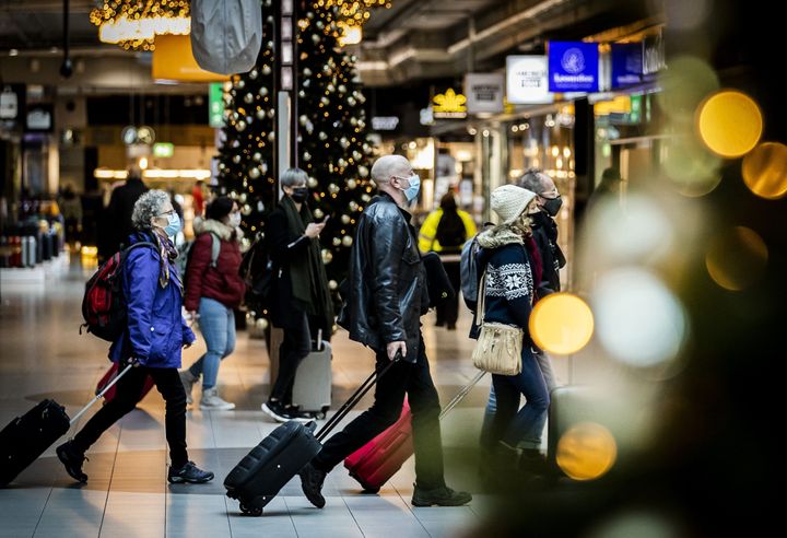 Travelers walk at the Schiphol Airport in the Netherlands on November 30, 2021. (Photo by REMKO DE WAAL/ANP/AFP via Getty Images)