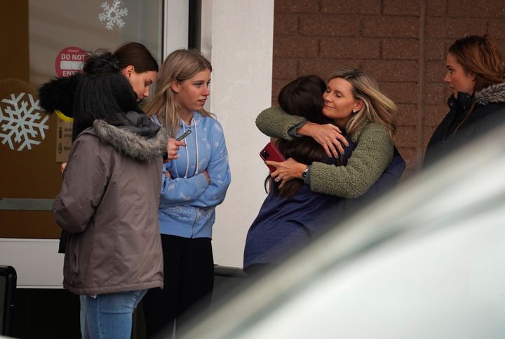 A parent hugs a child as others come to pick up students from the Meijer store in Oxford, Michigan, following a shooting at Oxford High School on Tuesday.